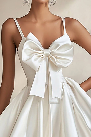 Une ligne robe de graduation blanche à bretelles spaghetti avec nœuds